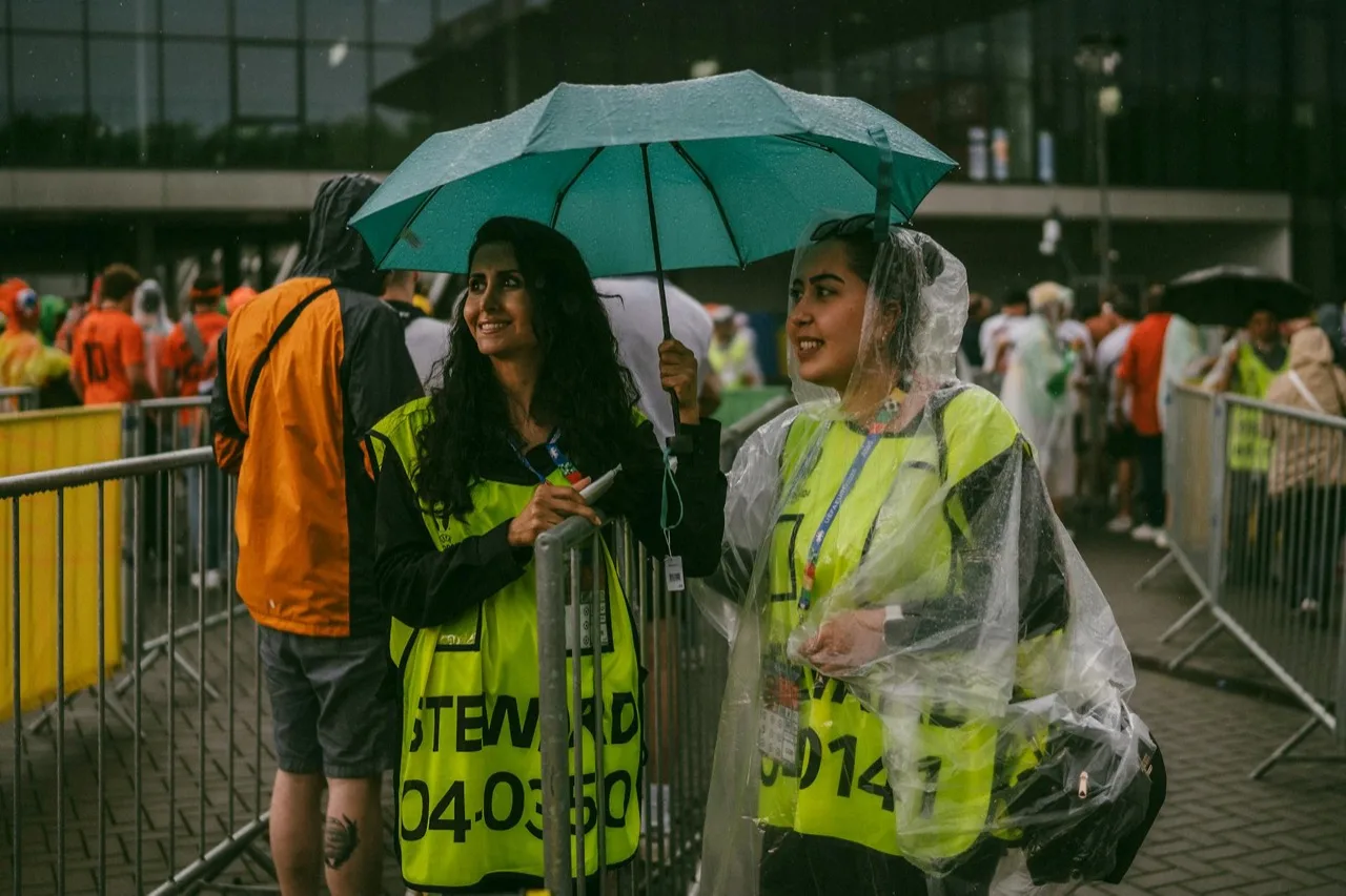 Crowd management stewards in hi-vis vests directing attendees at metal barriers at Canadian event
