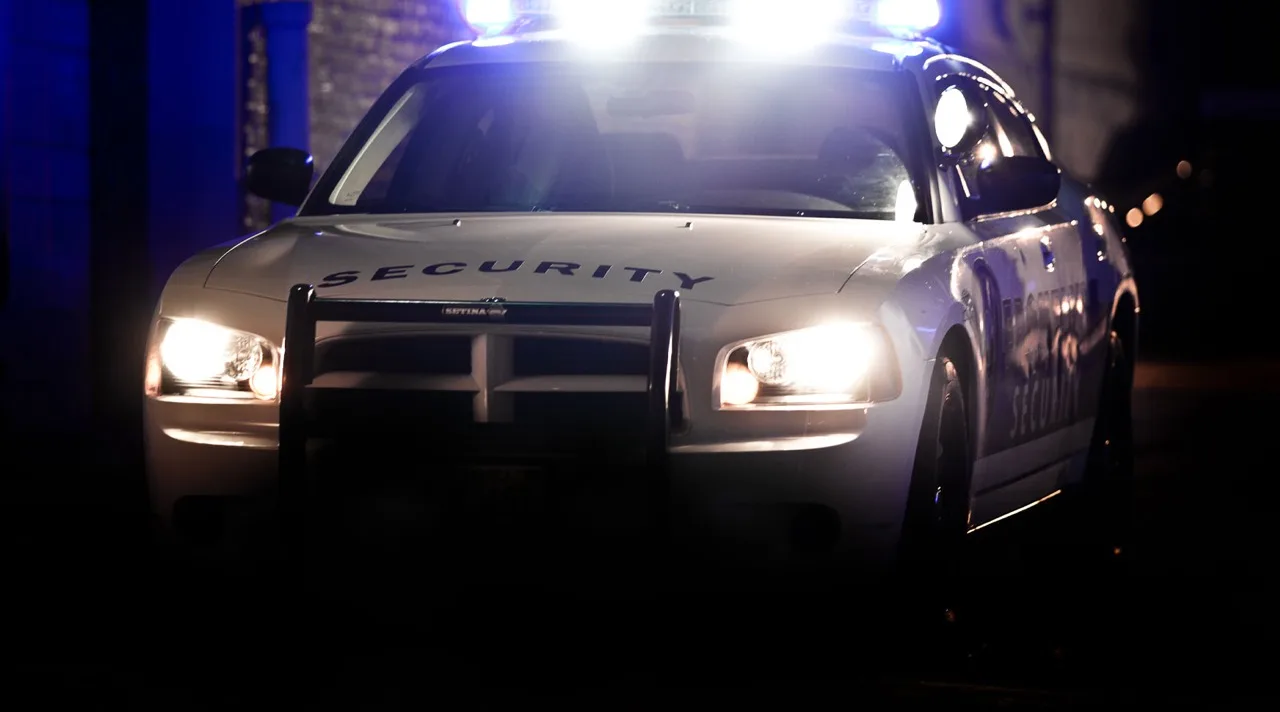Mobile patrol security vehicle with blue emergency lights on night patrol in Canada