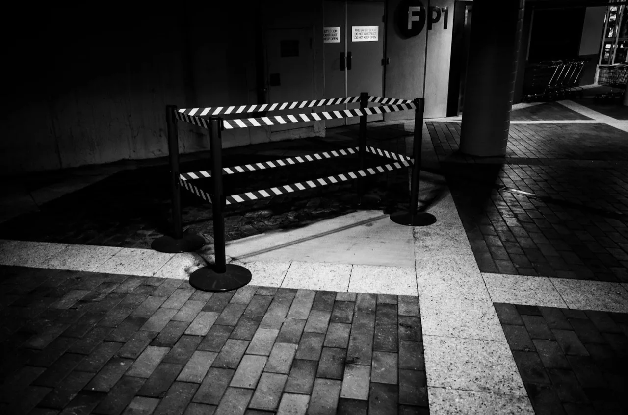 Retractable belt barrier stanchions with striped caution belts for queue management in Canada