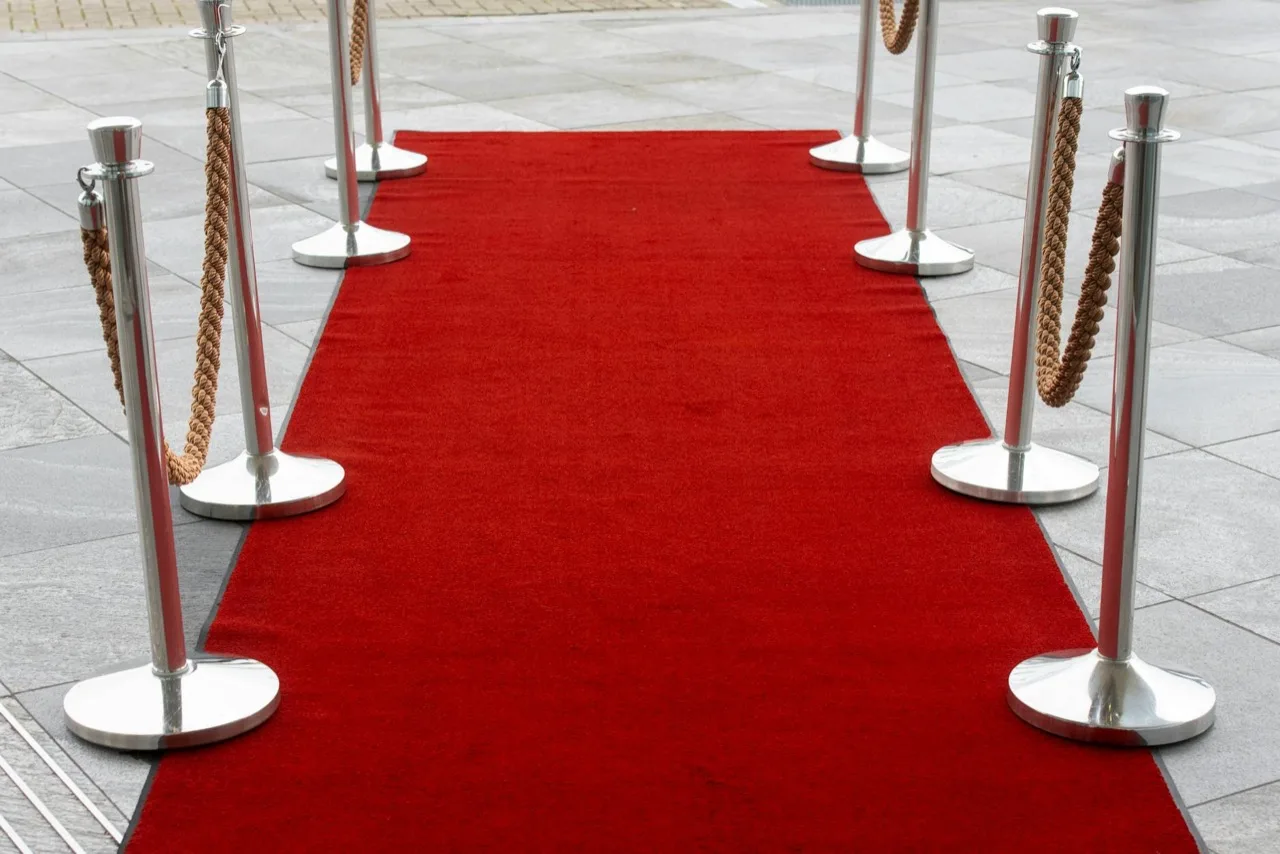 Chrome rope and post stanchions with twisted gold ropes lining red carpet entrance in Canada
